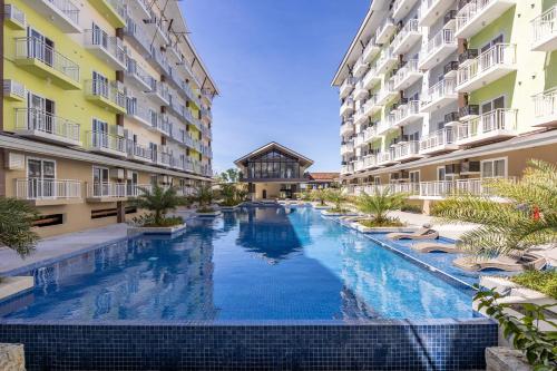 a swimming pool in the middle of two apartment buildings at 537 AMANI LUXURY SUITE, 3 Minutes to Airport,with Gym & Pool, FAST WI-FI, Free Netflix in Pusok