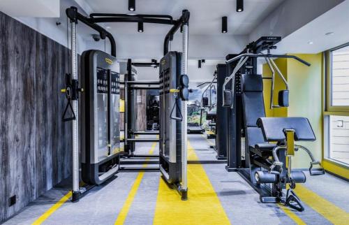 a gym with a row of treadmills and machines at OASIS AVENUE-A GDH HOTEL in Hong Kong