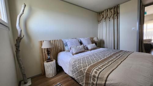 une chambre avec un grand lit avec des oreillers bleus dans l'établissement Vue Mer Exceptionnelle, à Marseillan