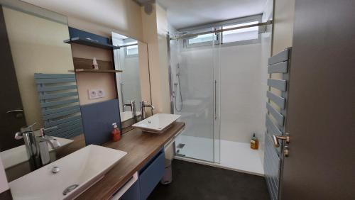 une salle de bain avec deux lavabos et une douche en verre dans l'établissement Vue Mer Exceptionnelle, à Marseillan