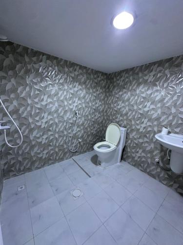 a bathroom with a toilet and a sink at استراحة الخيالة in Falaj al Mu‘allá