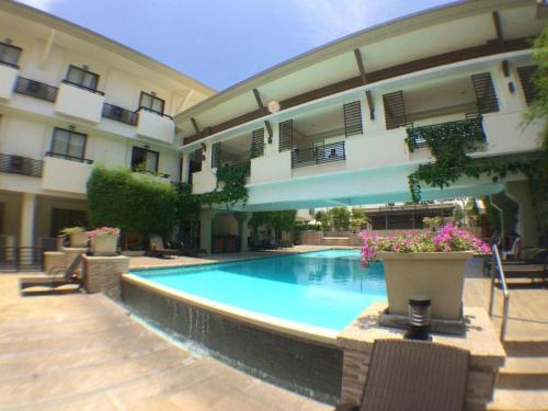 a swimming pool in front of a building at Mansion Garden Hotel in Olongapo