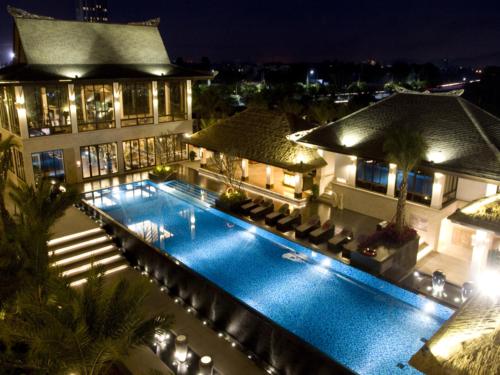 una piscina di fronte a un edificio di notte di Riyuegu Hotsprings Resort a Xiamen