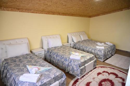 a room with three beds with towels on them at Joni Restaurant in Pogradec