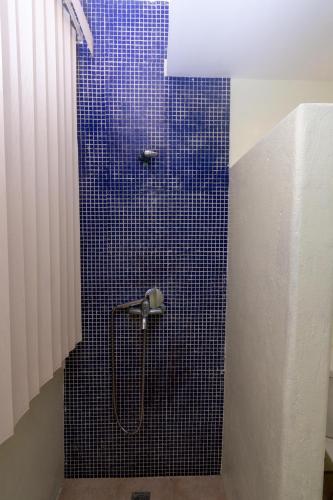 a bathroom with a shower with a blue tile wall at Babosam Apartments in Boracay