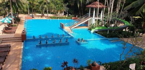 a large blue swimming pool with people in it at River Kwai Village Hotel in Ban Kaeng Raboet