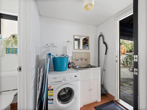 a laundry room with a washing machine and a sink at Riverside Margaret River in Margaret River Town