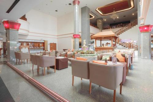 a restaurant with tables and chairs in a building at K.P. Grand Hotel Chanthaburi in Chanthaburi