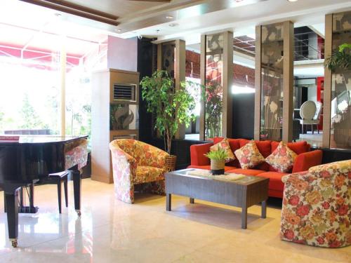 a living room with a couch and a piano at Hermes Palace Hotel Medan in Medan