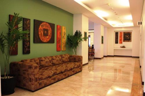 a living room with a brown couch in a room at Grand Surya Hotel Kediri in Kediri