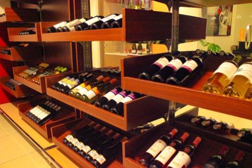a bunch of wine bottles on shelves in a store at Grand Surya Hotel Kediri in Kediri
