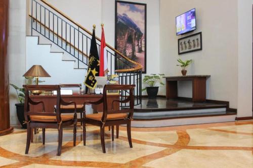 a room with a table and chairs and a staircase at Grand Surya Hotel Kediri in Kediri