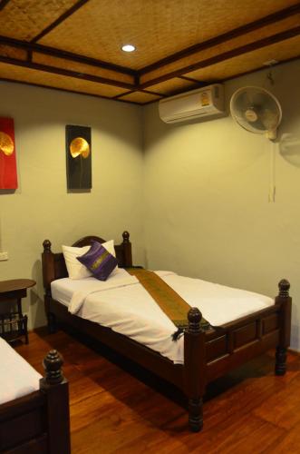 a bedroom with two beds and a fan at Baan Aew Pai in Pai