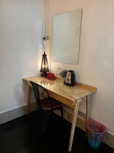 a wooden desk with a lamp and a tea kettle on it at La Locanda in Bangkok