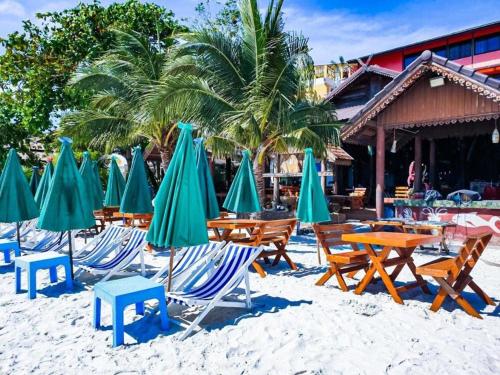 un gruppo di sedie e ombrelloni su una spiaggia di Jirawan Hotel a Ko Samed