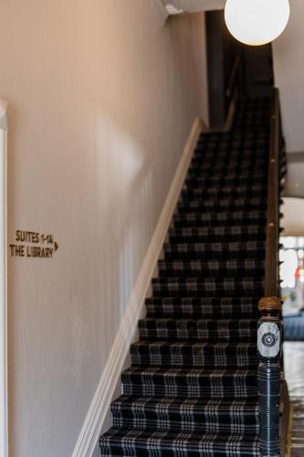 a stairway with a sign that reads smiles the library at The Victoria Hotel Rutherglen in Rutherglen