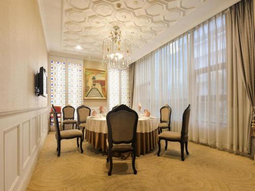 a dining room with a table and chairs and a chandelier at New Pearl River Hotel in Guangzhou