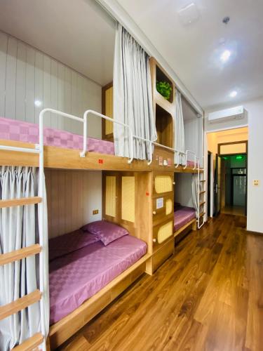 two bunk beds in a room with wooden floors at Hồng Vân Homestay in Cao Bằng