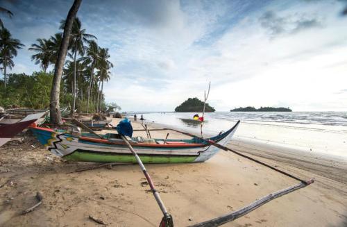 a boat sitting on the beach with two oars at The Axana Hotel in Padang