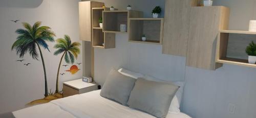 马霍礁Emerald Upscale Studio in Maho-Walking distance to beach的卧室配有一张床,墙上挂着棕榈树