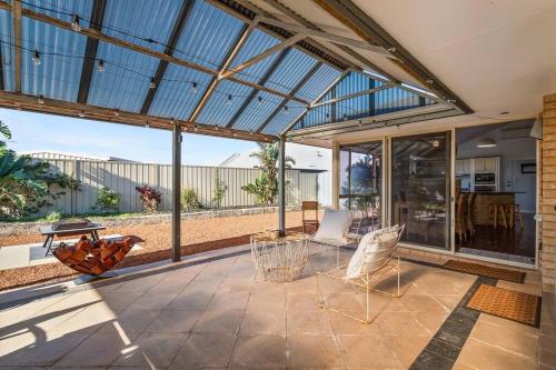 a conservatory with a patio with two chairs and a table at Beachside Family Friendly Escape at Casa Del Caravel in Mandurah