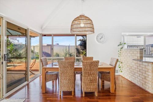 a dining room with a wooden table and chairs at Beachside Family Friendly Escape at Casa Del Caravel in Mandurah