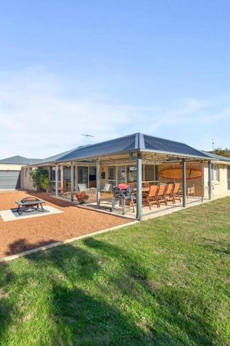 a house with a blue roof and a patio at Beachside Family Friendly Escape at Casa Del Caravel in Mandurah