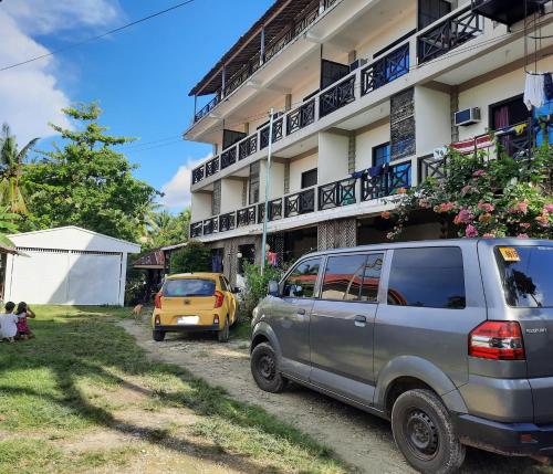 two cars parked in front of a building at Stanley House Seaview Apartments in Panglao