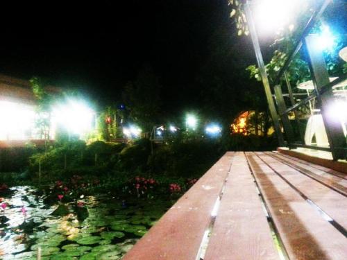 a walkway in a park at night with lights at BanRai ChernMa Resort in Tak