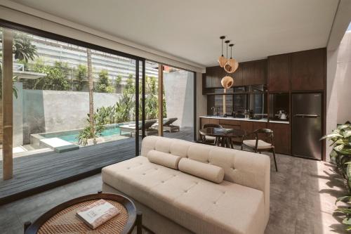 an open living room with a couch and a dining room at INSPIRA Seminyak in Seminyak