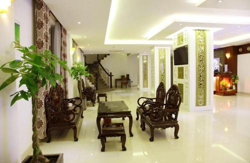 a lobby with chairs and a table and a plant at Rain Bow Hotel in Ho Chi Minh City