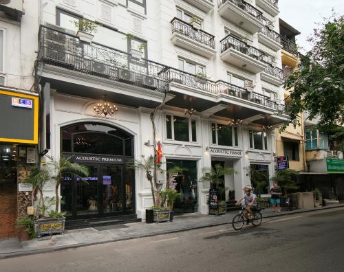 a person riding a bike in front of a building at Acoustic Premium Hotel & Spa in Hanoi