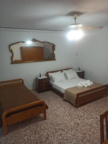 a bedroom with two beds and a mirror on the wall at Villa kakoliri in Taxiárkhai