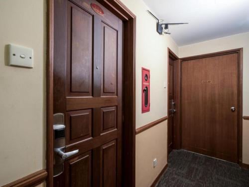 a hallway with a wooden door and a door at Four Chain View Hotel in Singapore