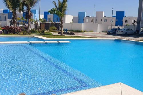 a large blue swimming pool in front of a building at Espectacular y Nuevo in Gallinero