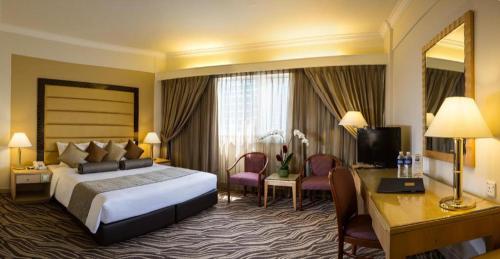 a large hotel room with a bed and a desk at Hotel Miramar Singapore in Singapore