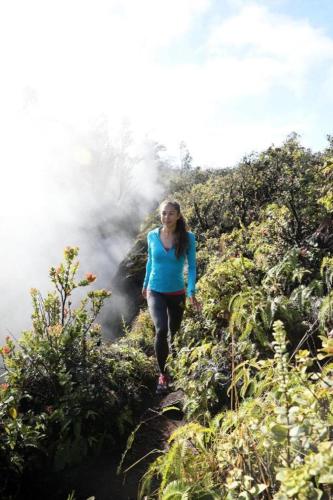 a woman walking up a hill in the jungle at Volcano House in Volcano