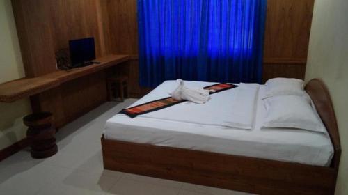 a bedroom with a bed with a blue curtain at Lankham Hotel in Pakse
