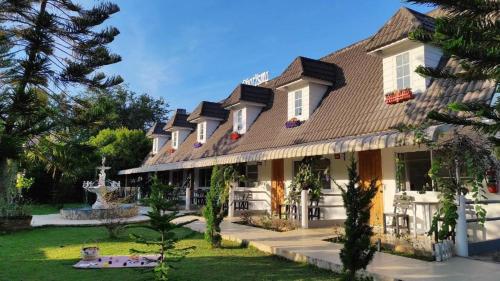 a large building with a fountain in the yard at Charisma Resort in Ratchaburi