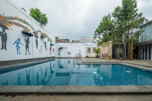 a swimming pool with a mural on the side of a building at The Silk at Dago Boutique Hotel in Bandung