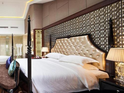 a bedroom with a large bed with a large headboard at Eden Club House in Tongxiang