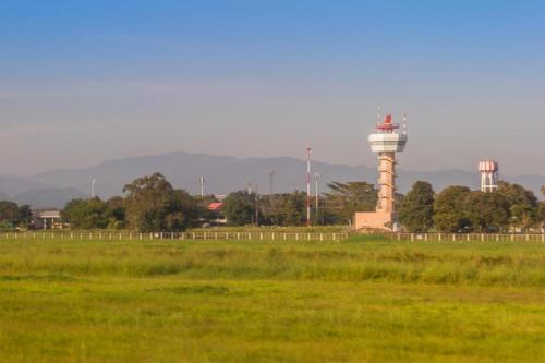 a lighthouse in the middle of a field with a grass field at So Herbs at Home in Chiang Rai
