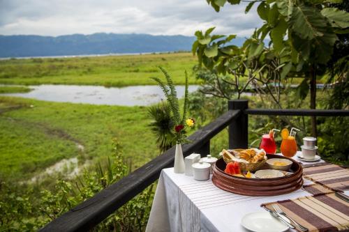 a table with a basket of food on it with a view of a field at Villa Inle Boutique Resort in Nyaung Shwe