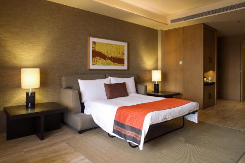 a bedroom with a large bed with two tables and two lamps at JW Marriott Los Cabos Beach Resort & Spa in San José del Cabo