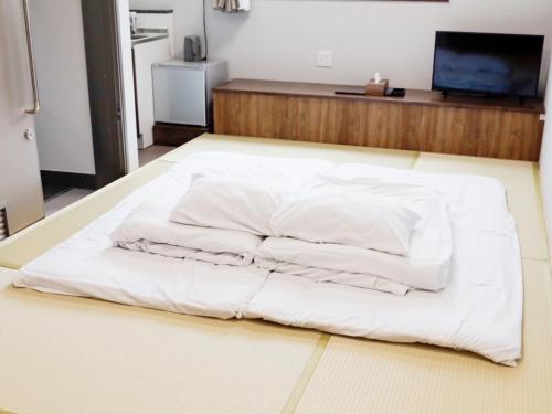 a white bed sitting on the floor in a room at HOTEL KANALOA in Tokashiki