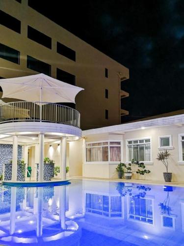 a swimming pool with an umbrella in front of a building at Awesome Hotel in San Juan