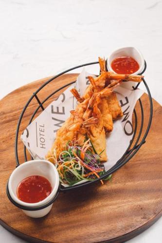a plate of food on a wooden board with two sauces at Awesome Hotel in San Juan