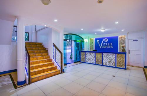 a lobby with a staircase in a building at Vitalis White Sands in Vigan