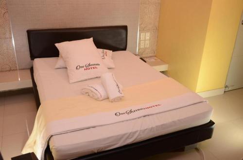 a bed with white sheets and pillows in a room at One Serenata Hotel General Trias in Silang
