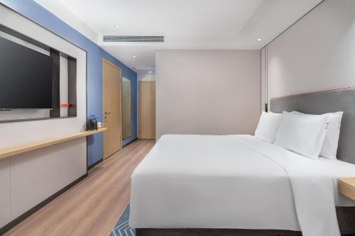 a bedroom with a large white bed and a flat screen tv at Holiday Inn Express Xi'an Daxing by IHG in Xi'an